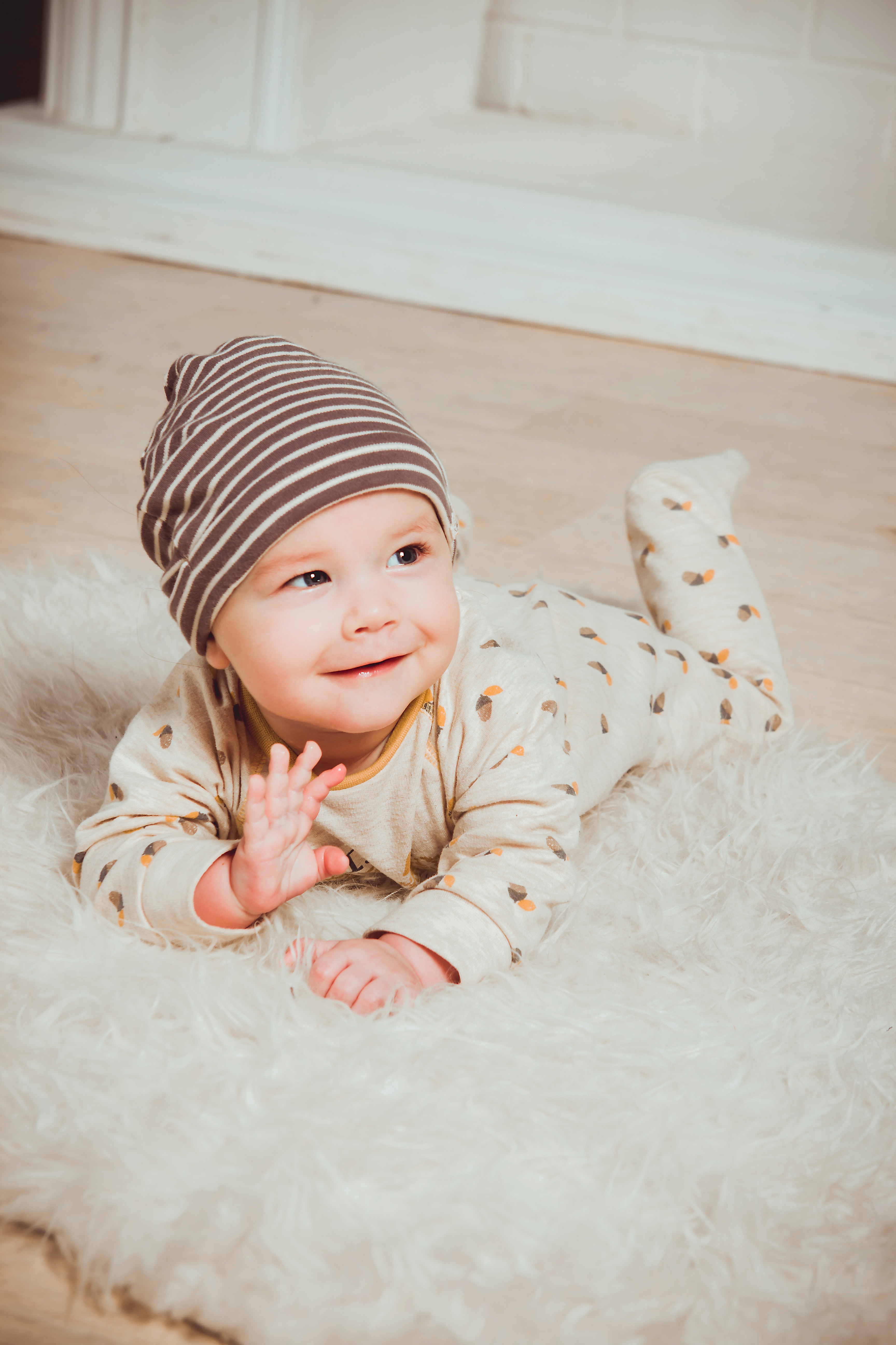 Kinderbetreuung Thun: Glückliches Baby in Bauchlage auf Fell